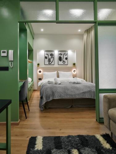 Un dormitorio con una cama y una pared verde. en Plane Tree Luxury Suites, en Ioannina