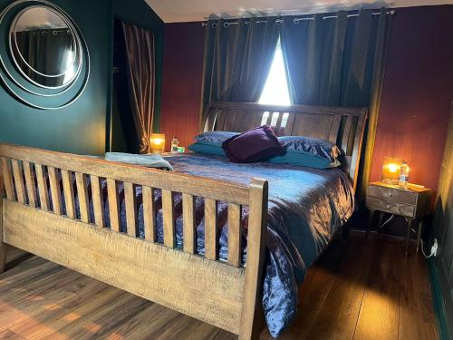 a bedroom with a wooden bed with blue sheets and a mirror at Jackson place in Newton Aycliffe