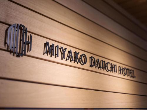 a wooden wall with a sign that reads mimickaka dalemark at Miyako Daiichi Hotel in Miyako Island