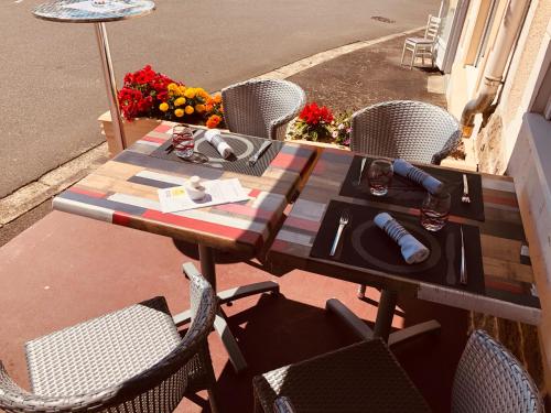 a wooden table with chairs on a patio at Restaurant Hotel Logis Chez Sophie in Briouze