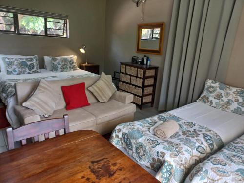 a living room with two beds and a couch at A Little Guesthouse in Bloemfontein