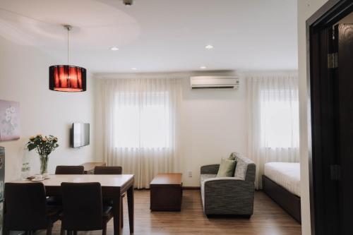 1 dormitorio y sala de estar con mesa de comedor. en Song Hưng Hotel & Serviced Apartments - Căn hộ Dịch vụ & Khách sạn en Ho Chi Minh