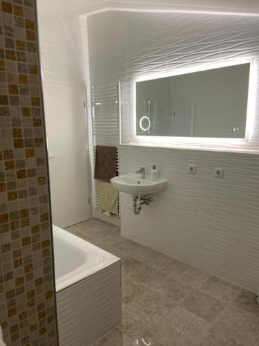 a bathroom with a sink and a tub and a mirror at Sleep2Fly Hamburg-Airport in Hamburg