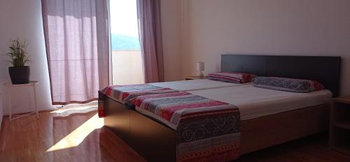 a bedroom with a bed with a large window at Apartmani Barišić in Trogir