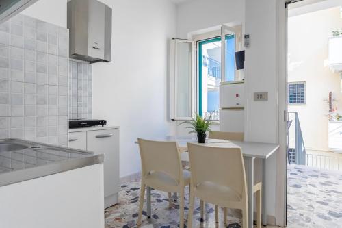 een witte keuken met een tafel en stoelen bij Saporedimare - fronte mare - Narramondo Villas in Tortoreto Lido