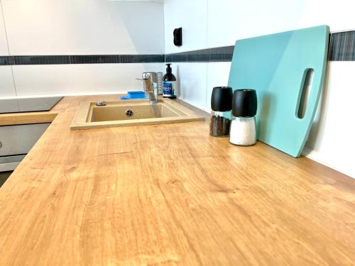 a kitchen with a sink and a wooden floor at Apartament Aviator in Mielec