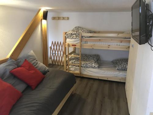 een kamer met 2 stapelbedden en een bank bij Arcs 1800 Duplex rénové 5 pers au pied des pistes calme location à la semaine seulement in Arc 1800