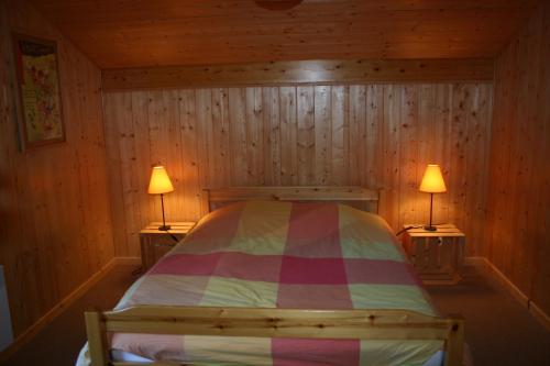 ein Schlafzimmer mit einem Bett mit zwei Lampen an zwei Tischen in der Unterkunft LATITUDE 47 in Châtel