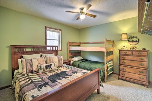 a bedroom with two bunk beds and a ceiling fan at Wooded Danbury Cabin with Grill and Fire Pit! in Danbury