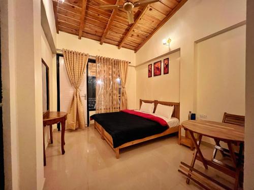 RAMSHILA COTTAGE في Bhowāli: غرفة نوم بسرير وطاولة ونافذة
