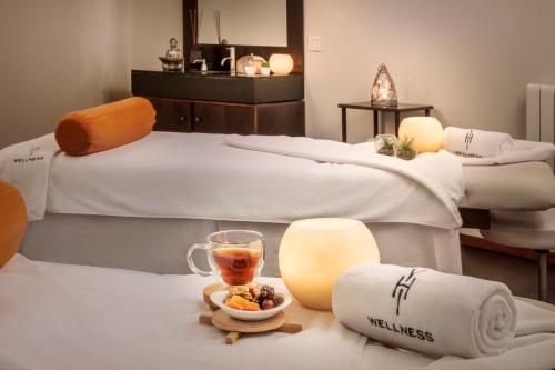 two beds with towels and a drink and a plate of food at Melia Sierra Nevada in Sierra Nevada