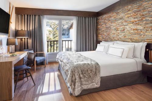 a hotel room with a bed and a brick wall at Melia Sierra Nevada in Sierra Nevada