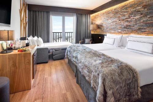 a hotel room with two beds and a brick wall at Melia Sierra Nevada in Sierra Nevada