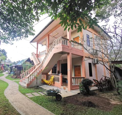 a house with a staircase on the side of it at Cheers Garden Chalet in Kampung Tekek