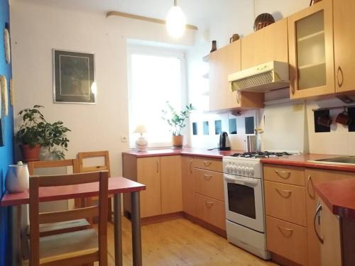 cocina con mesa y fogones horno superior en Klimatyczne mieszkanie w doskonałej lokalizacji en Varsovia