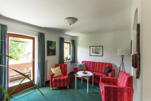 a living room with a red couch and chairs at Haus Abendsonne in Reit im Winkl
