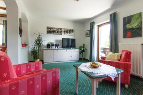 a living room with red chairs and a table at Haus Abendsonne in Reit im Winkl