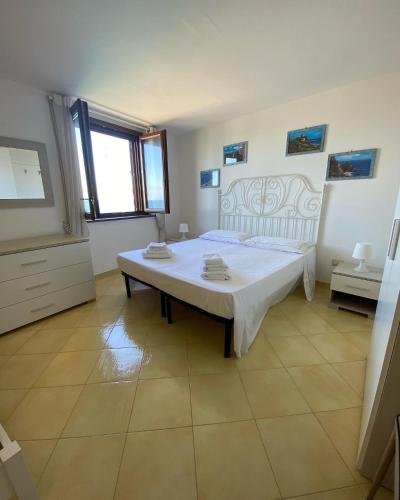 a bedroom with a white bed and a table at BlueMind in Tropea