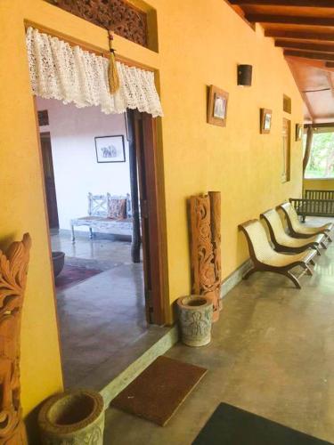 a living room with chairs and an open door at Eth Mansala in Sigiriya