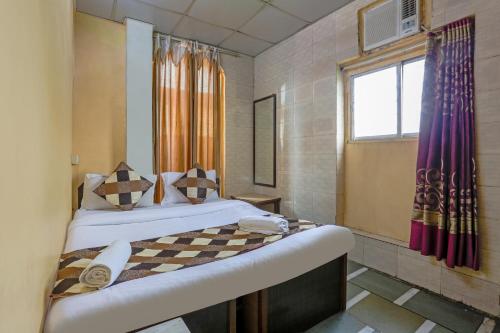 sypialnia z łóżkiem i oknem w obiekcie Terminus Hotel Bandra w Bombaju