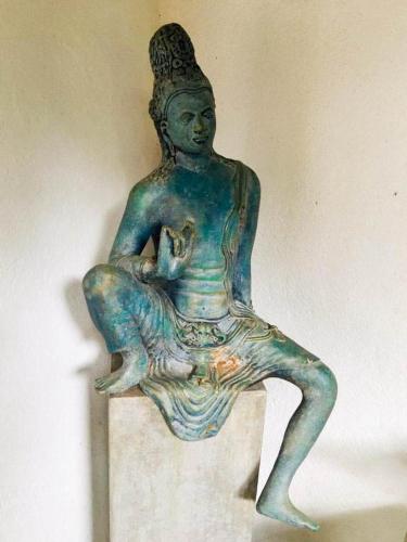 a statue of a woman sitting on a wall at Eth Mansala in Sigiriya