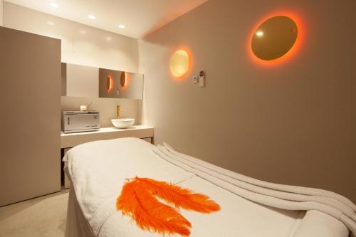 a bedroom with a bed with feathers on it at Hotel Montecarlo Spa & Wellness in Roses