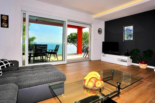 a living room with a couch and a glass table at Villa Karmen Adriatica in Kukljica