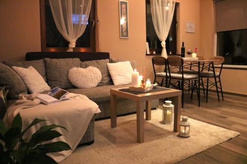 un soggiorno con divano e tavolo con candele di Guest house - studio apartman Marina a Karlovac