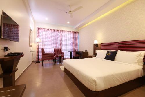 a hotel room with a bed and a table and chairs at The One Hotel in Aurangabad