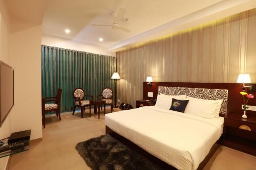a hotel room with a bed and a table and chairs at The One Hotel in Aurangabad