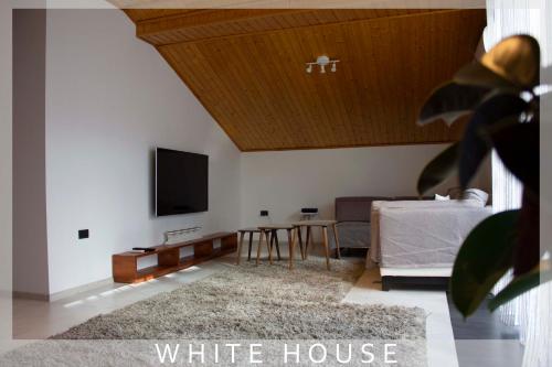 ein Wohnzimmer mit einem weißen Haus und einem Flachbildfernseher in der Unterkunft White House in Tbilisi City