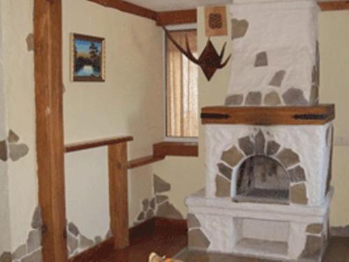 a living room with a stone fireplace in a room at Gogol Hotel in Myrhorod