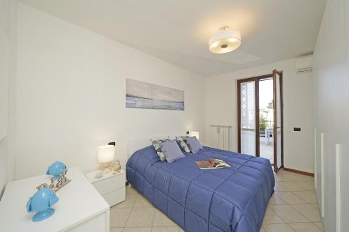 una camera bianca con letto blu di Appartamento Chiaretto - Gardagate a Moniga