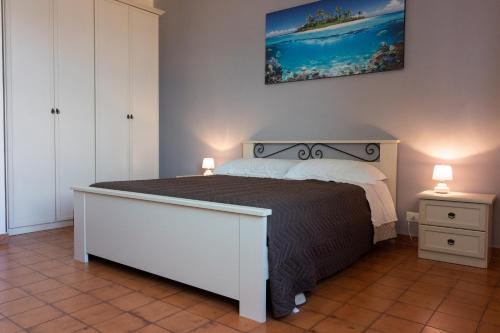 パレルモにあるcasavacanzabordonaroのベッドルーム(白い大型ベッド、ランプ2つ付)