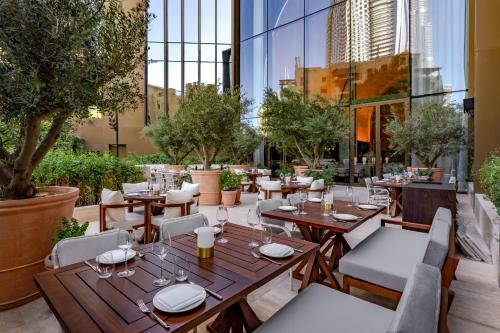 restauracja ze stołami, krzesłami i drzewami w obiekcie The Dubai EDITION w Dubaju