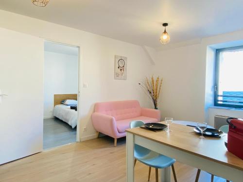 uma sala de estar com um sofá rosa e uma mesa em LE CLOS RUTHÈNE em Rodez