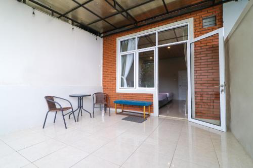 a patio with a table and chairs and a window at Alinson Sunset Hill in Bogor
