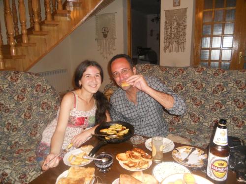 a man and a woman sitting at a table with food at Nitsa Guest House in Gori