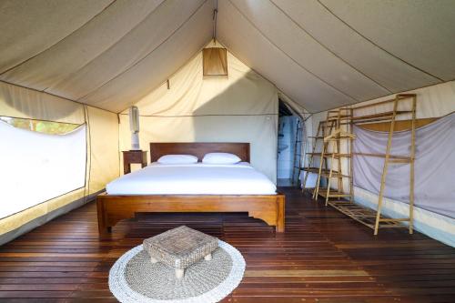 a bedroom with a bed and a table in a tent at Alinson Sunset Hill in Bogor