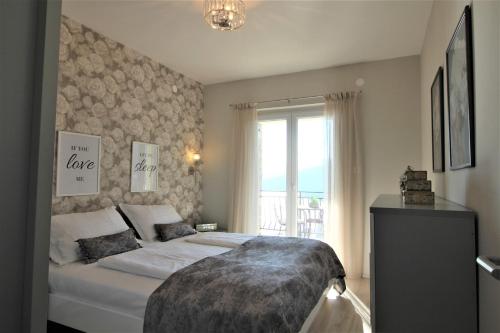 a bedroom with a large bed and a window at Apartments Marina in Rabac