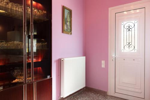 a room with a pink wall and a white door at Golden Seaside House number 2 in Eantio