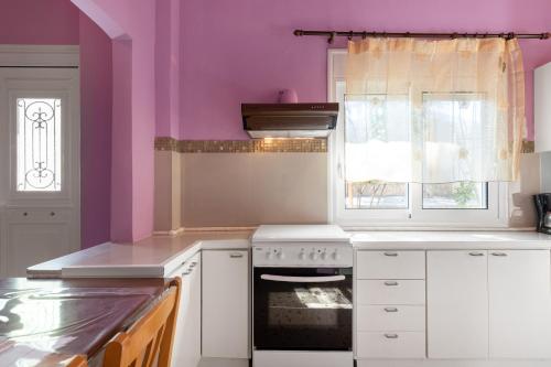 a kitchen with pink walls and a stove and a window at Golden Seaside House number 2 in Eantio