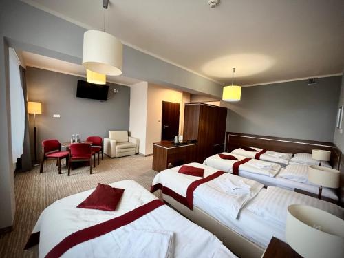 a hotel room with two beds and a dining room at Hotel Szyndzielnia Eco in Bielsko-Biała