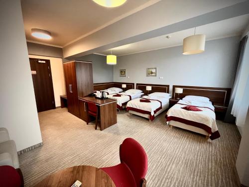 a hotel room with three beds and a table and chairs at Hotel Szyndzielnia Eco in Bielsko-Biała