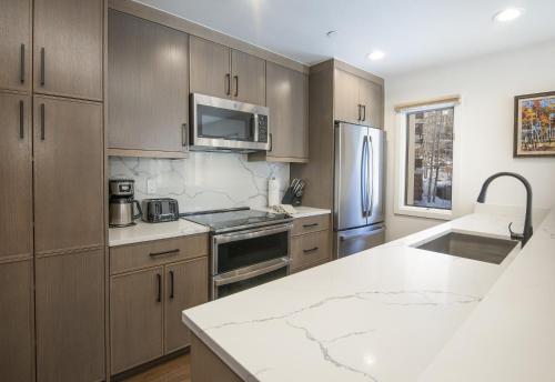 a kitchen with wooden cabinets and a stainless steel refrigerator at Townsend Place B202 Condo in Beaver Creek