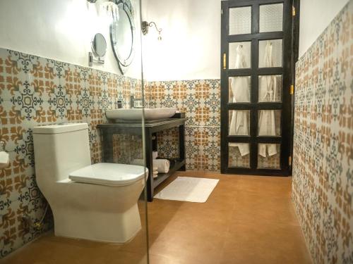 a bathroom with a toilet and a sink at Fort Tiracol Goa in Arambol