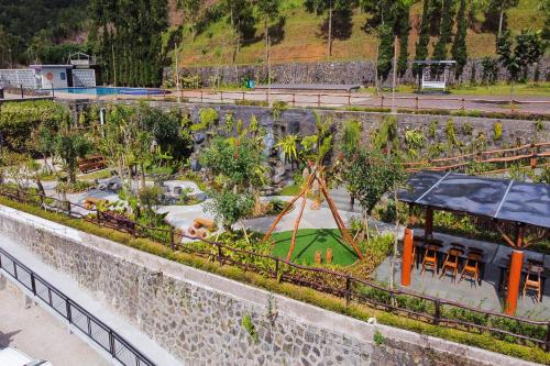 an outdoor garden with a playground and trees at Alinson Sunset Hill in Bogor