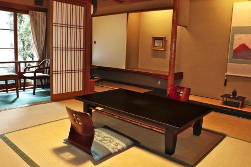 a living room with a table and a chair at Tsutaya Ryokan in Toyooka