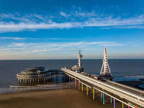 a bridge over the ocean with a lighthouse on it at Helena at Sea Apartments in Scheveningen