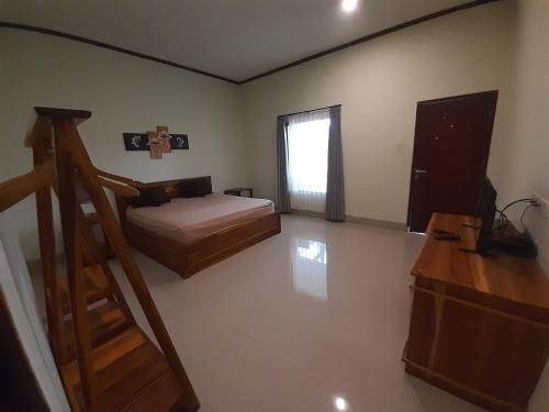 a bedroom with a bed and a staircase in it at kamala in Selong Belanak